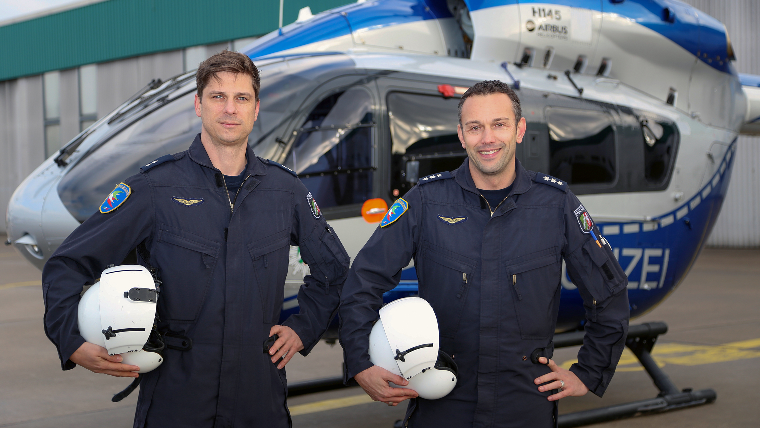 Two pilots in front of a police helicopter