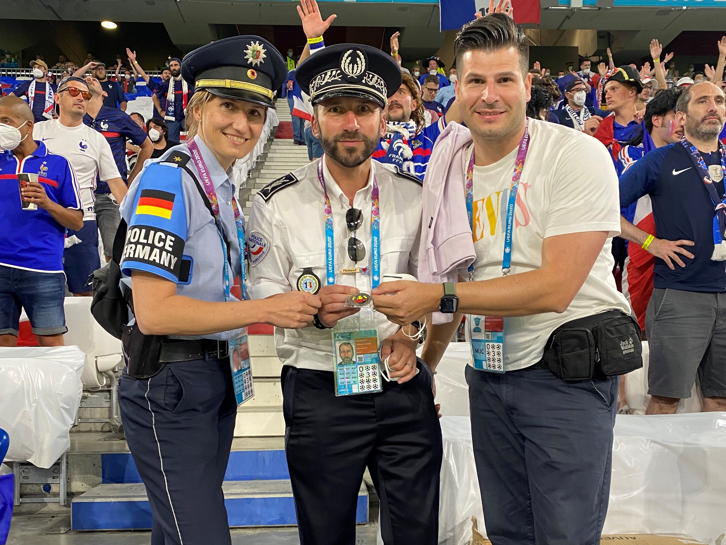 Zwei Polizisten und eine Polizistin aus verschiedenen Nationen zusammen im Stadion