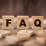 Auf einem Tisch sind flache Holzquadrate mit Buchstaben verteilt. Mitten drin stehen drei Quadrate aufrecht. Auf ihnen sind die Buchstaben F, A und Q zu sehen. 